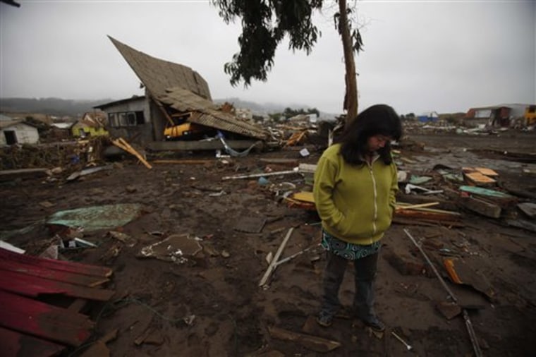 Rosa Neira, 36, stands in front of a house damaged by the tsunami that hit Pelluhue, about 200 miles southwest of Santiago, Chile, on Sunday.